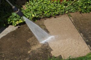 An R&J Painting professional cleaning a patio in Chicago, showing the benefits of local expertise in pressure washing services.