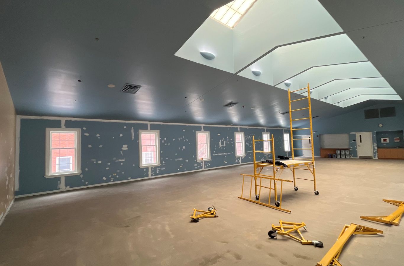 An R&J Painting team member painting an office interior in Cary, IL, demonstrating the benefits of professional commercial painting services.