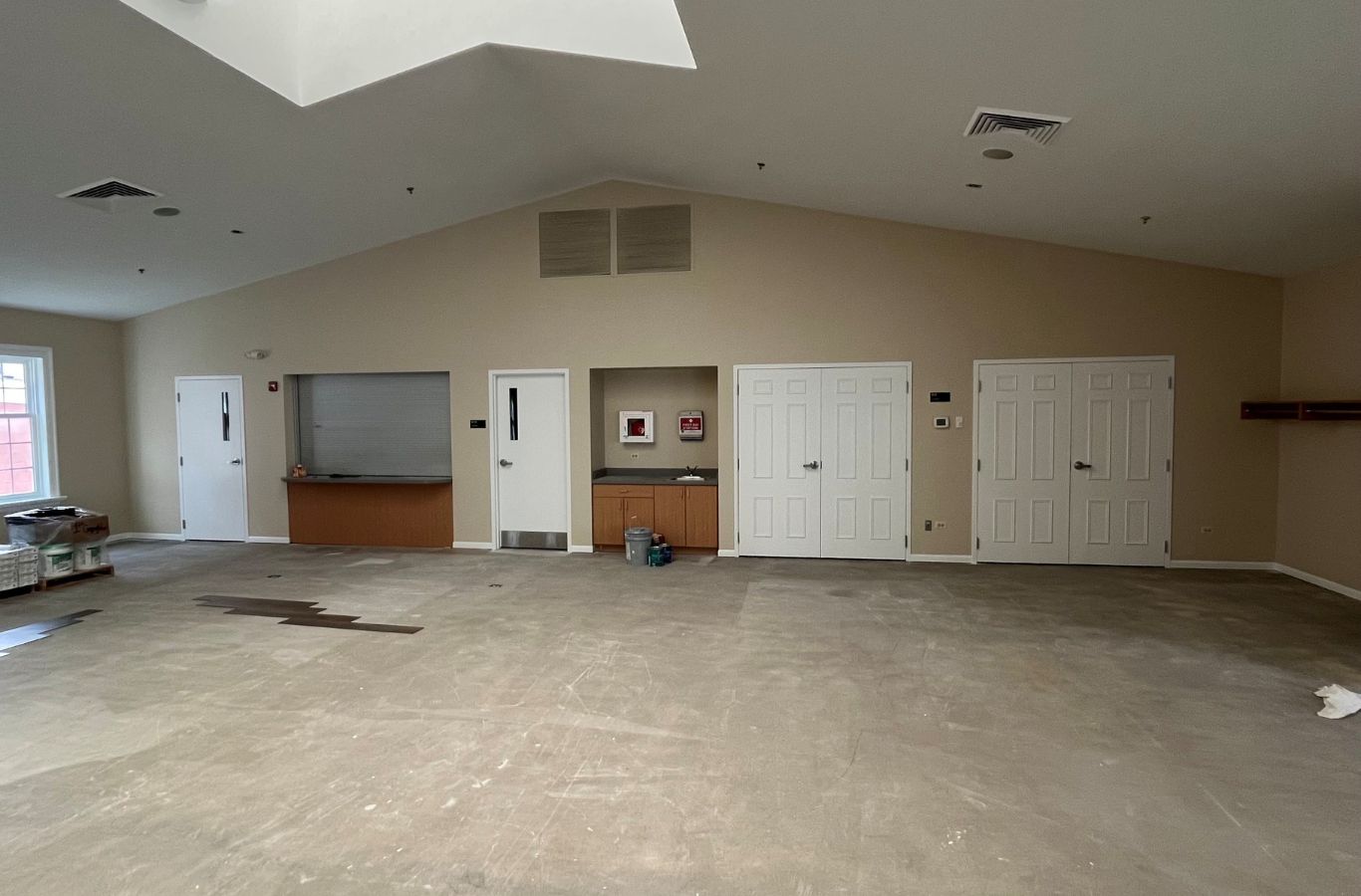 A skilled R&J Painting team member painting an office interior in Schaumburg, IL, showcasing the advantages of expert painting services.